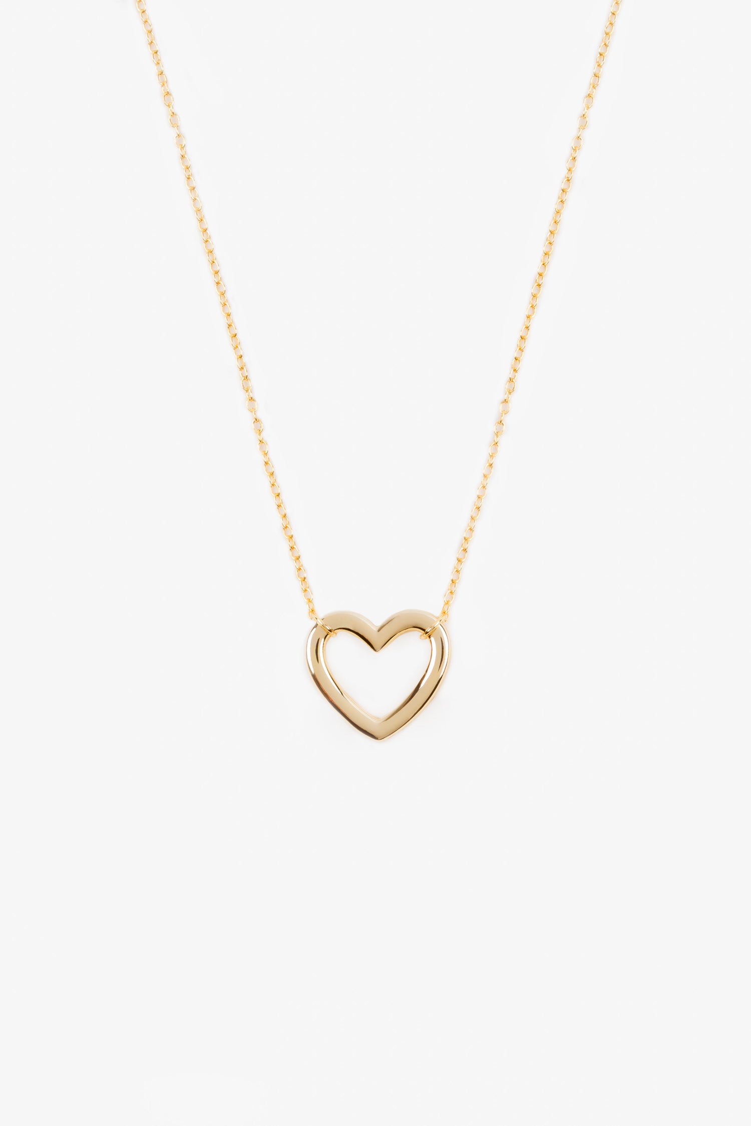 gold plated heart shaped pendant on a gold chain. necklace is on a white background