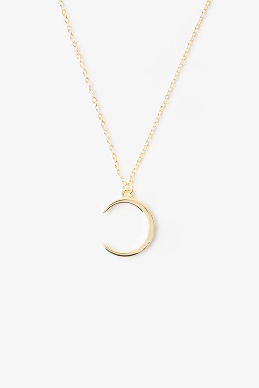 new crescent moon shaped pendant necklace on a gold plated chain. its on a white background