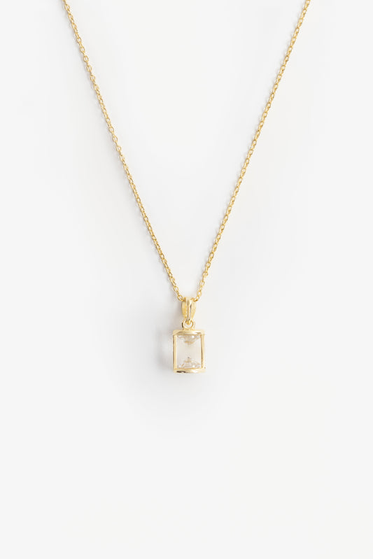hourglass shaped pendant with two cubic zirconia diamond shapes at either end on a gold chain